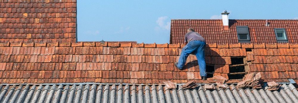 Mann repariert rotes Dach